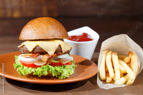 burger and french fries on the wooden table.