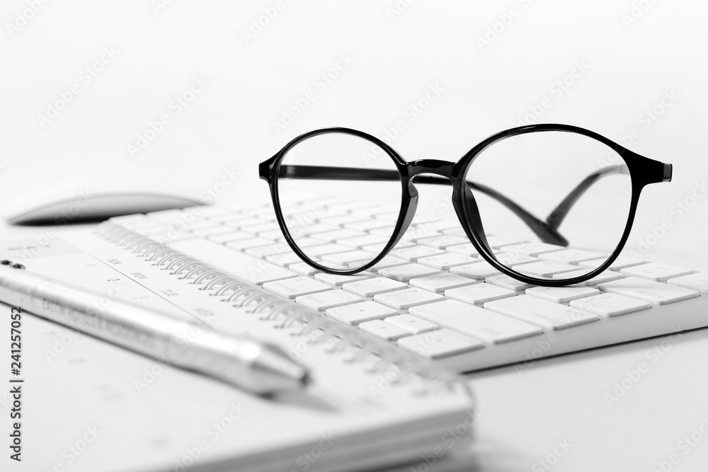 Office supplies, Glasses at a desk with a computer keyboard , business concept Office supplies, Glasses at a desk with a computer keyboard , business concept