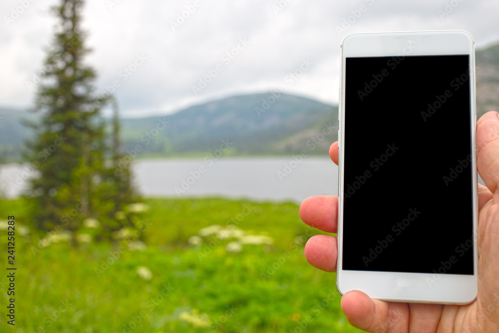 man using phone in mountains