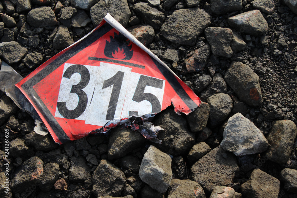 Torn flammable and explosive sticker on the road backgroound. concept accident Torn flammable and explosive sticker on the road backgroound. concept accident