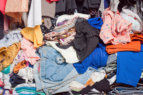 Pile of messy clothes in closet. Untidy cluttered woman.
