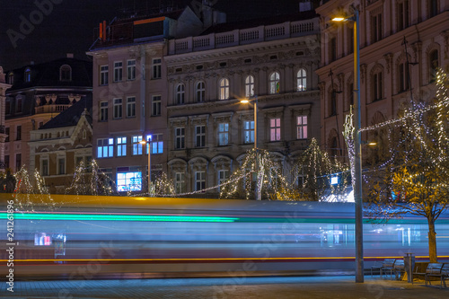 Light trails of tram at Liberty Square in Brno, christmas decoration on tree.