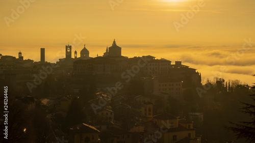 Bergamo, one of the most beautiful city in Italy. Amazing landscape of the old town and the fog covers the plain at sunrise