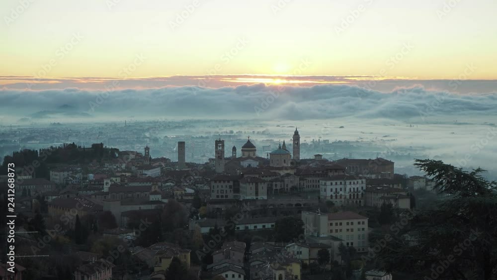 Bergamo, one of the most beautiful city in Italy. Amazing landscape of the old town and the fog covers the plain at sunrise Bergamo, one of the most beautiful city in Italy. Amazing landscape of the old town and the fog covers the plain at sunrise