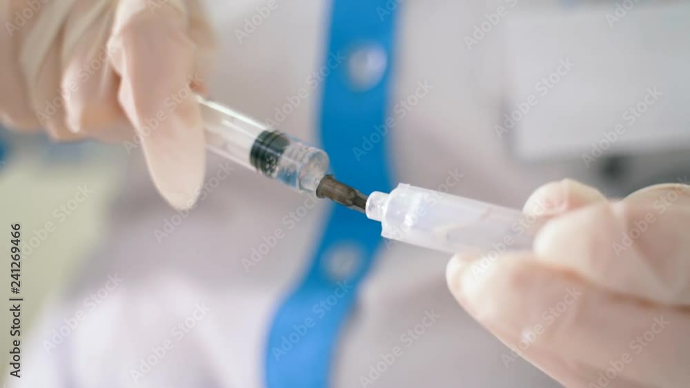 health worker dials the vaccine into a syringe. Close-up health worker dials the vaccine into a syringe. Close-up