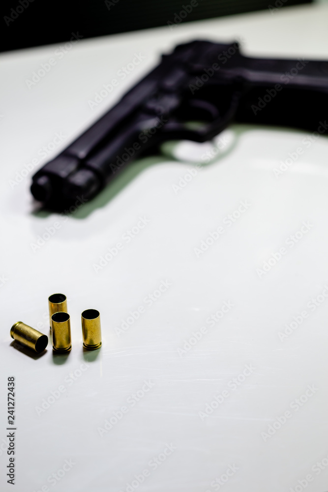 Handgun with 9mm shell casings on white table