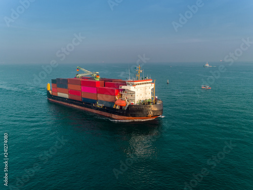 Container ship on the sea port and working crane bridge load full of container for logistics import export, shipping or transportation.