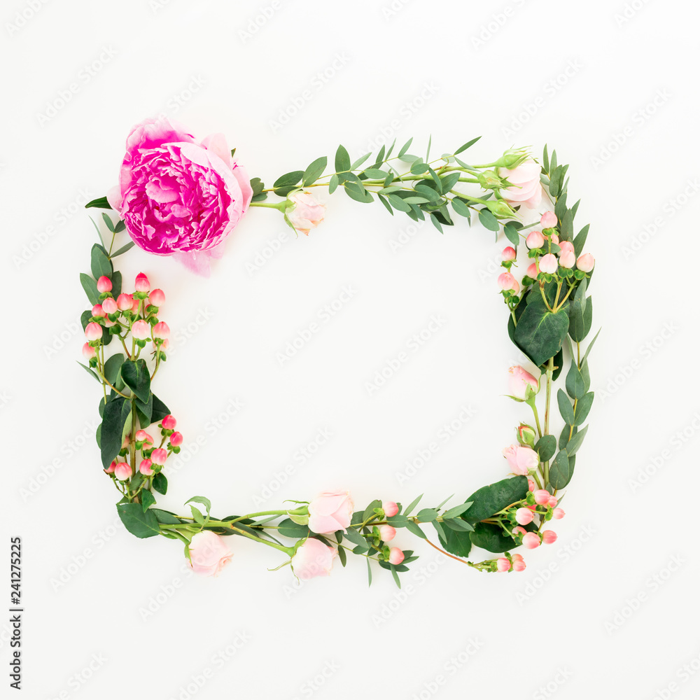 Floral frame of pink flowers, hypericum and eucalyptus branches on white background. Flat lay, top view