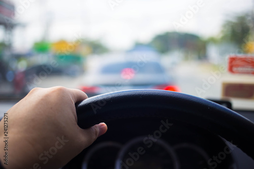people driving car on day time for background usage.(take photo from inside focus on driver hand)