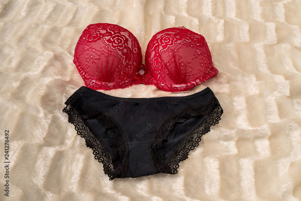 Red Bra and Black Panties on Beige Cloth Stock Photo - Image of