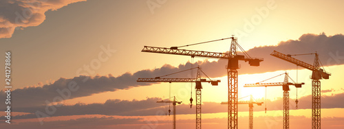 Construction cranes at sunset photo