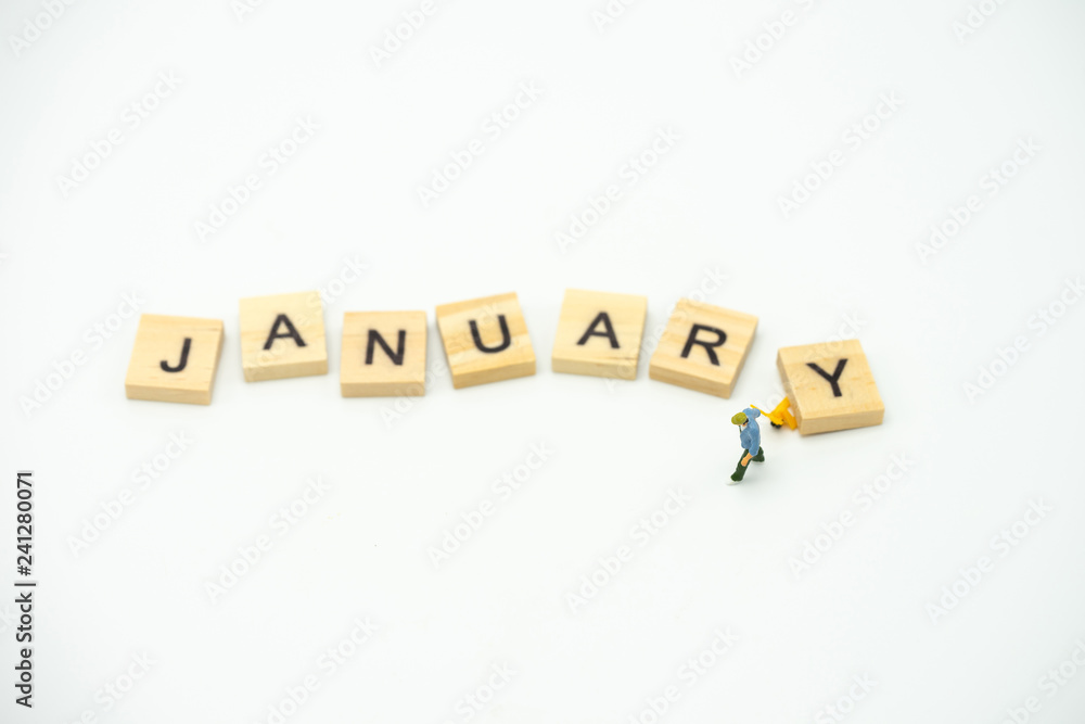 Obraz premium Miniature people Construction worker standing with wood word Month. using as background business concept and calendar concept with copy space for your text