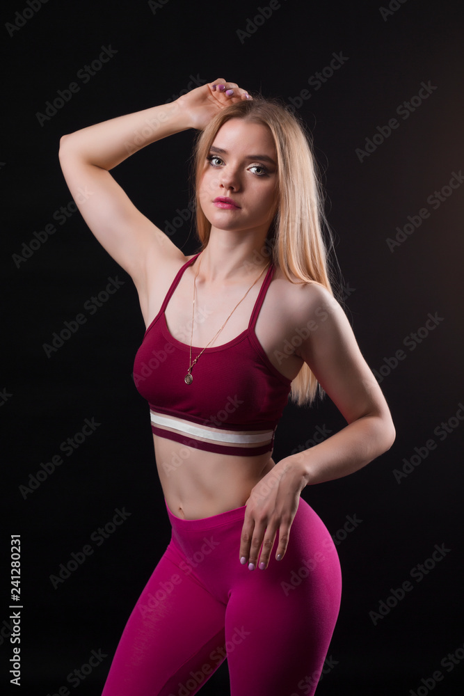Curvy athletic woman in sport outfit on black background. Curvy athletic woman in sport outfit on black background.