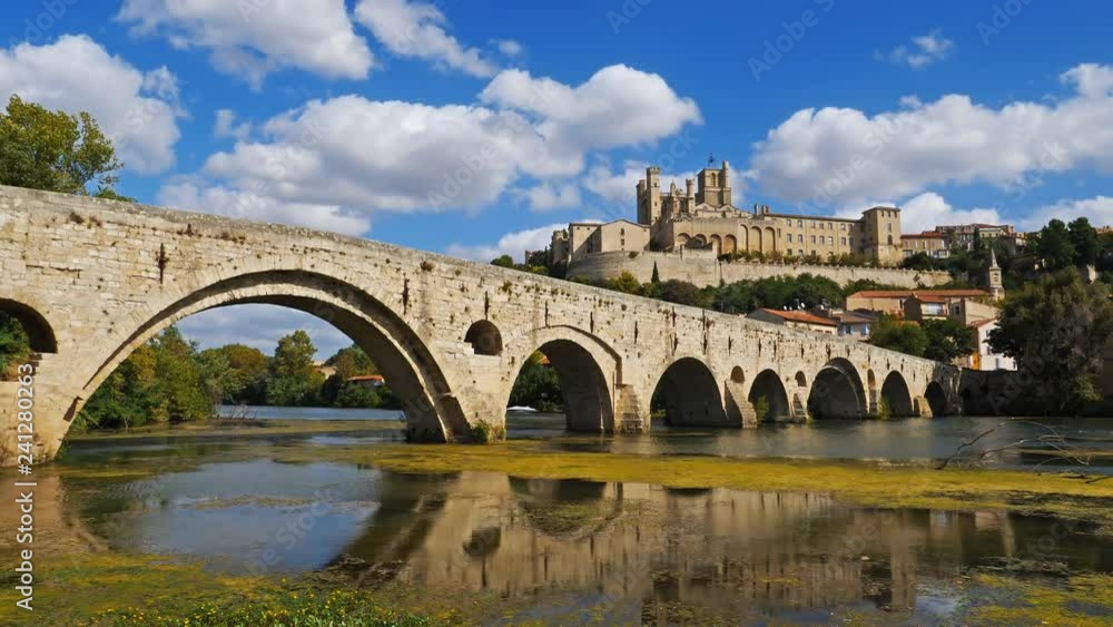 Beziers, Herault, Occitanie, France. In the foreground, the old bridge over crossing the Orb river. In the background is the cathedral Saint Nazaire Beziers, Herault, Occitanie, France. In the foreground, the old bridge over crossing the Orb river. In the background is the cathedral Saint Nazaire