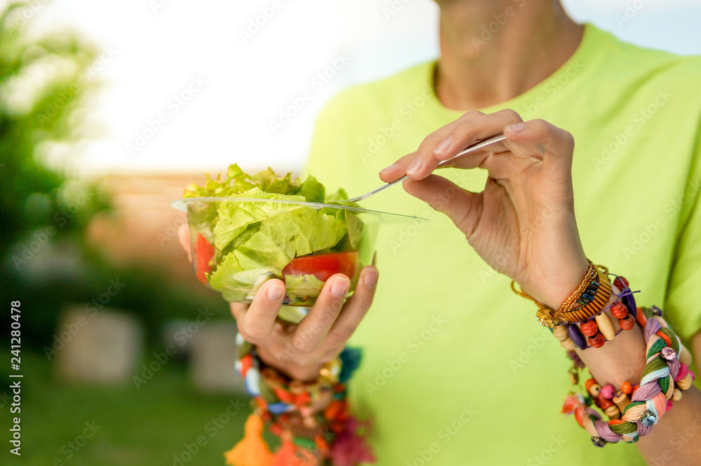 Woman hands holding bowl with salad