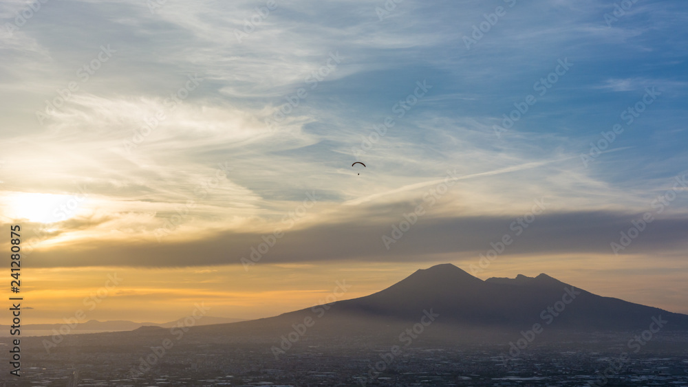 Overview of Naples and its Vesuvius while someone paragliders