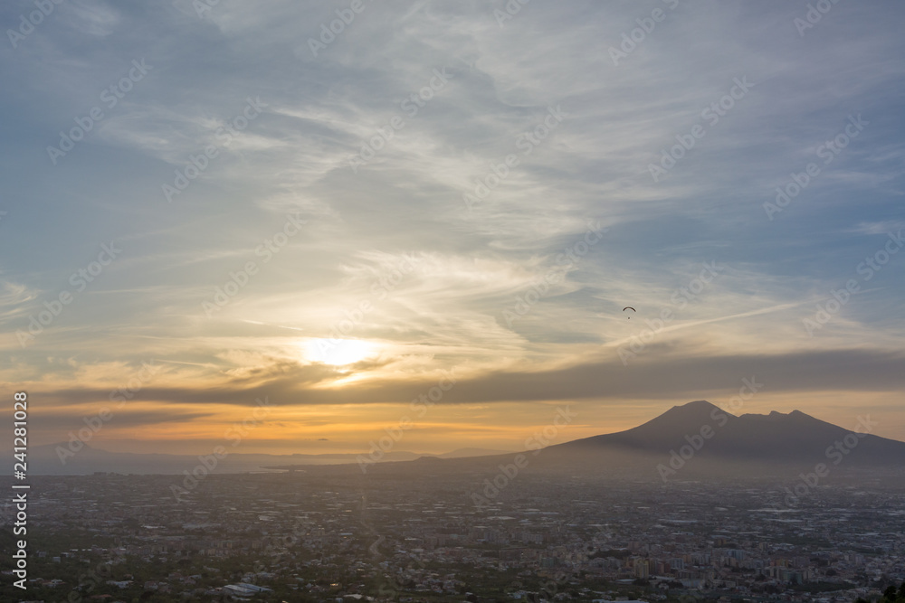 Overview of Naples and its Vesuvius while someone paragliders