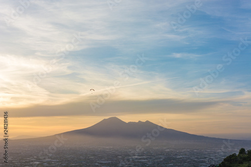 Overview of Naples and its Vesuvius while someone paragliders