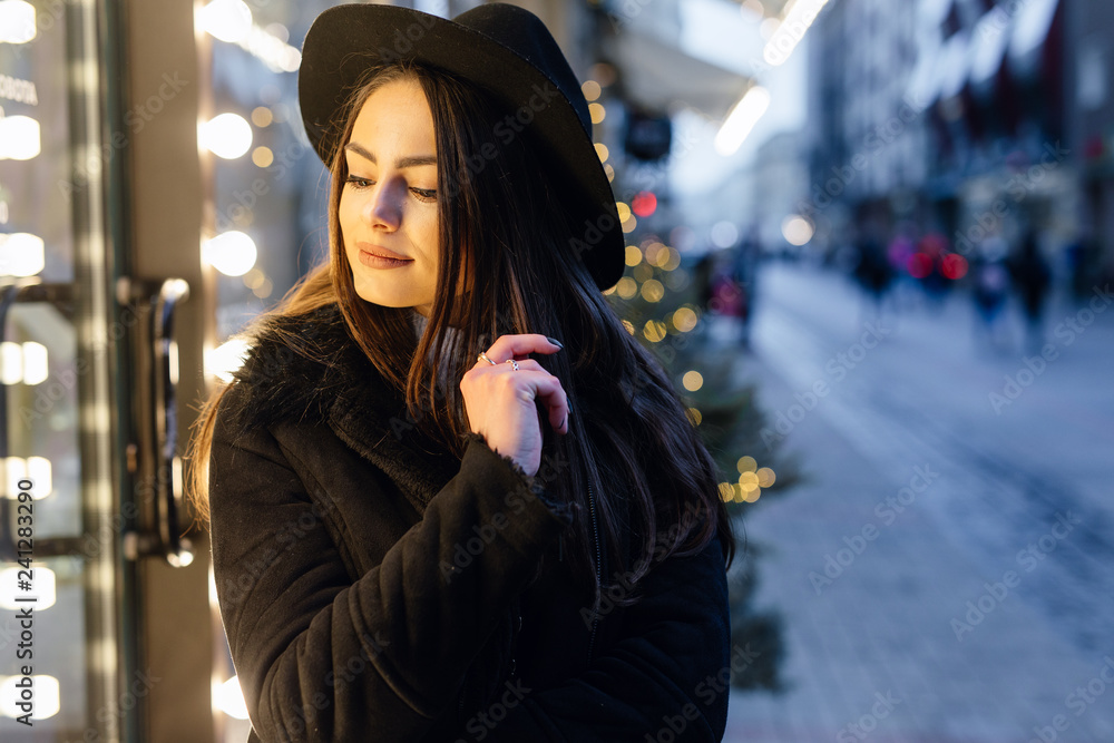 Pretty girl stand on the street wear black hat, look at window store and make funny expressions on her face. - Image Pretty girl stand on the street wear black hat, look at window store and make funny expressions on her face. - Image