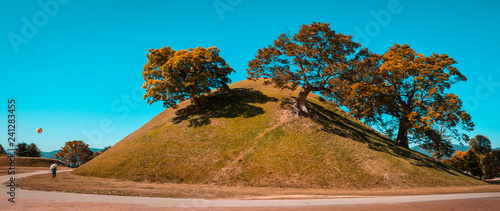 Fotografie Tumuli royal tomb in autumn foliage backgroung
