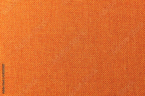 Textured background surface of textile upholstery furniture close-up. Orange color fabric structure © yanik88