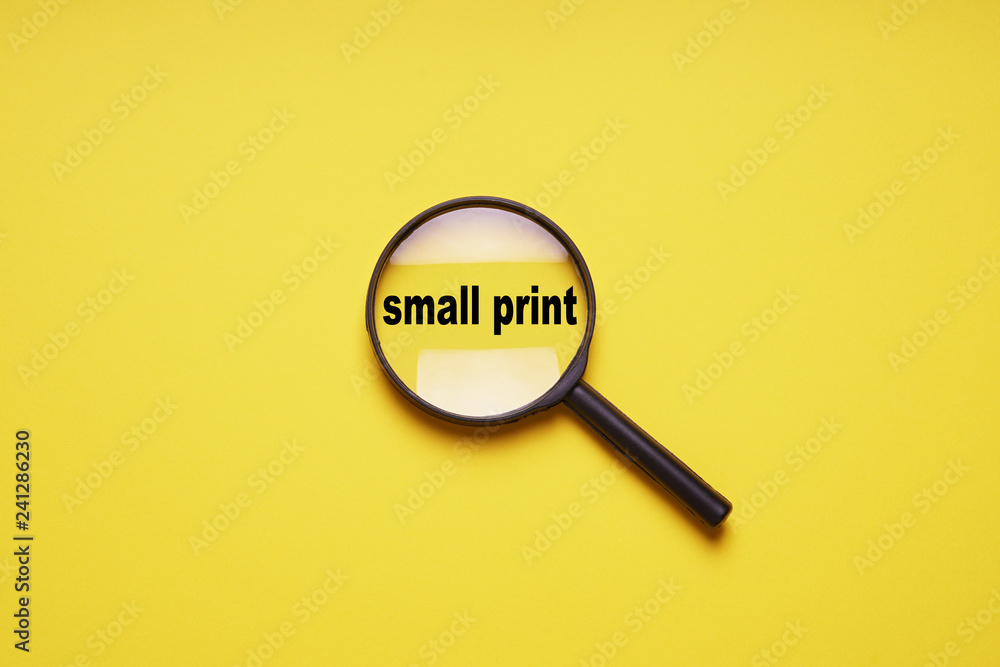 small print enlarged with magnifying glass magnifier loupe, minimal concept on yellow background with copy space small print enlarged with magnifying glass magnifier loupe, minimal concept on yellow background with copy space