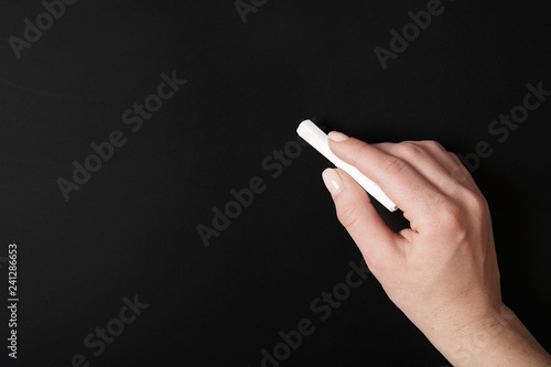 Картината върху платно female hand hand writing with chalk on blank chalkboard background with copy spa