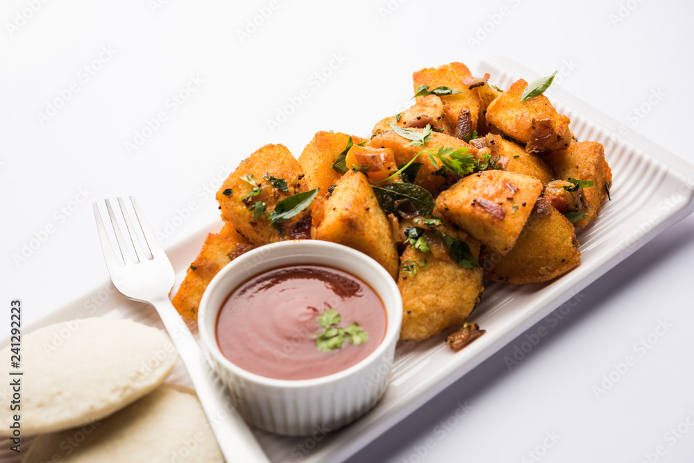 Masala fried Idlies or Idli fry - south indian Snack made using with leftover idly served with tomato ketchup. selective focus Masala fried Idlies or Idli fry - south indian Snack made using with leftover idly served with tomato ketchup. selective focus