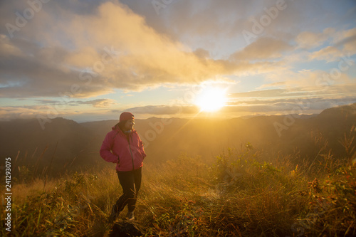 rear of happy woman stand on top mountain looking view with sunrise and mist at Doi Langka Luang, Chiang Rai province. soft focus. © suparat1983