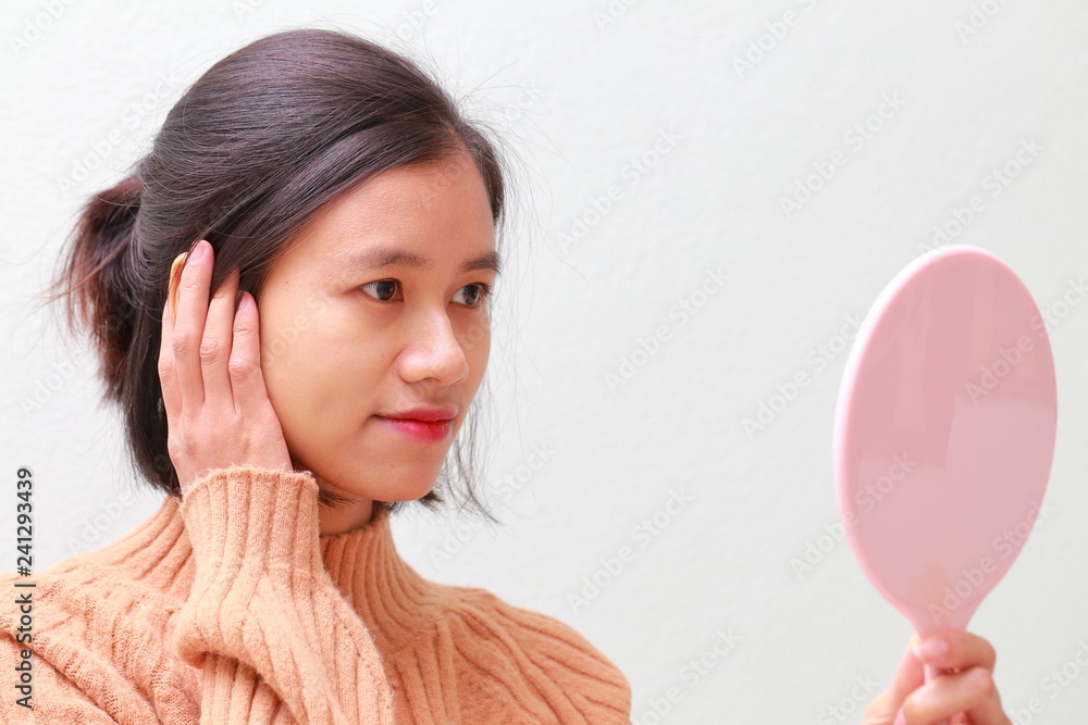 young woman using a hand mirror young woman using a hand mirror