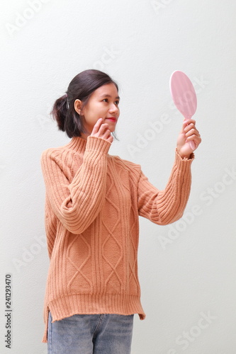 young woman using a hand mirror