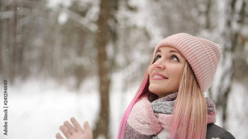 Outdoor close up portrait of young beautiful happy smiling girl wearing white knitted beanie hat, scarf and gloves. Model posing in street. Winter holidays concept. Outdoor close up portrait of young beautiful happy smiling girl wearing white knitted beanie hat, scarf and gloves. Model posing in street. Winter holidays concept.