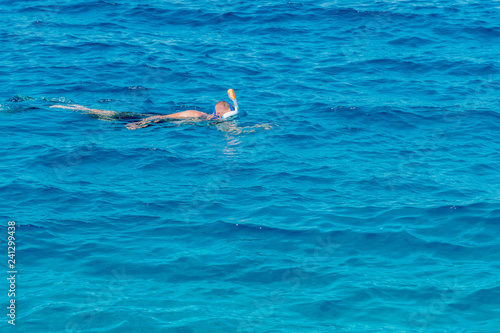 man with snorkel mask tuba and snorkel in sea. Snorkeling, swimming, vacation. Tourists are engaged in snorkeling in the open sea. Holidays in the seaside resort.