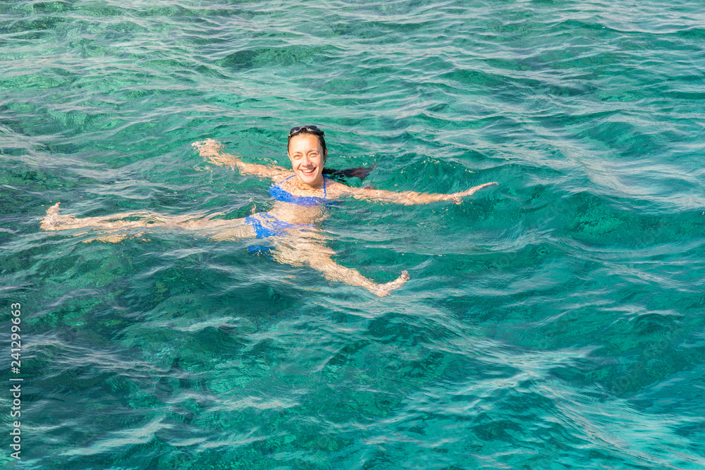Beautiful girl swiming at tropical island. Woman swiming in the sea. copy space.