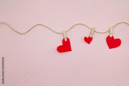 Valentine day background with red hearts hanging on the clothesline.