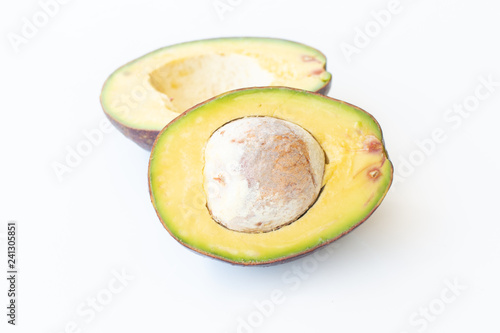 Two slices of avocado on a white background