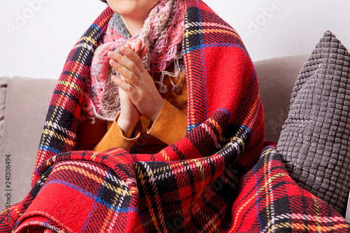 Woman feeling freeze and wrap up in a blanket.