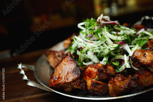 Shish kebab, kebab on a dark background. Different fried meat in plate