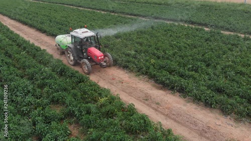 Agriulture,tractor,manuring.Tractor fertlizing cultivated field.Drone view photo