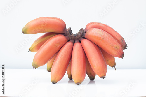 Bunch of ripe Cavendish banana or red bananas fruit on white table and white background