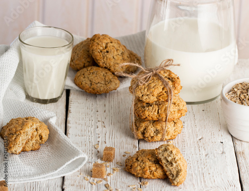 Oatmeal cookies with milk on tray on rustic wooden table