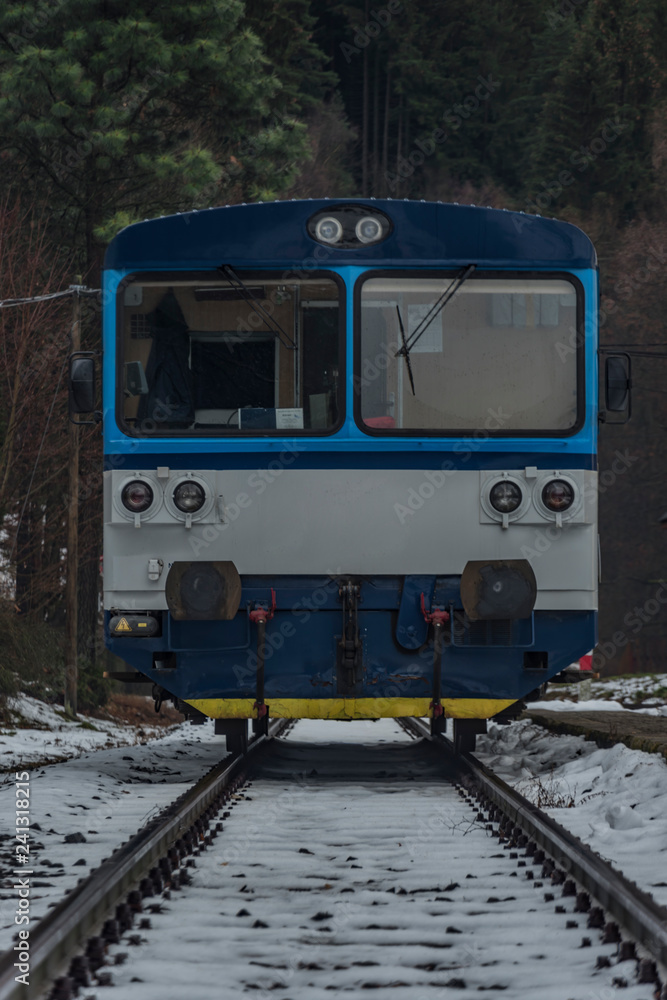 Merklin station in Krusne mountains in winter dark day with diesel blue train