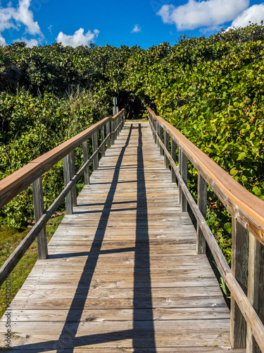 Fototapeta Naklejka Na Ścianę i Meble -  The wooden pathway over the dunes to the beach