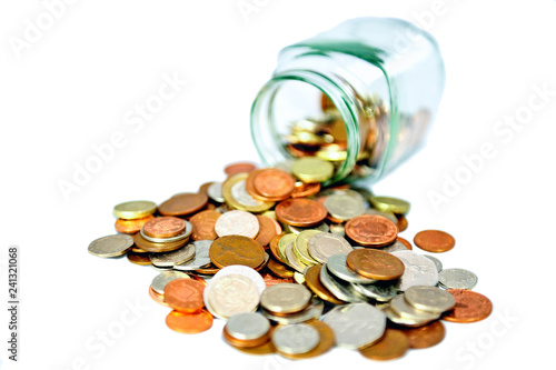 cut out of Glass jar full of uk British coins spilling out on white background