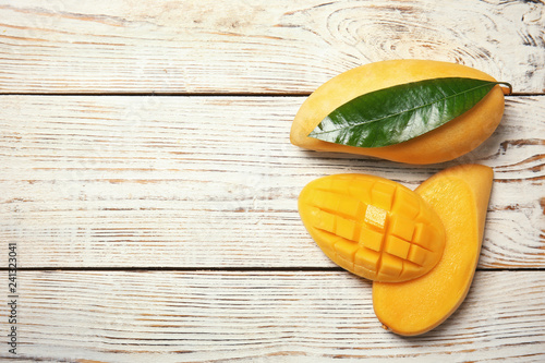 Flat lay composition with mango fruits on wooden background. Space for text photo