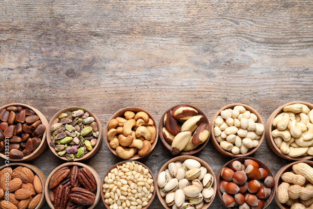 Flat lay composition with organic nuts and space for text on wooden background, top view. Snack mix Flat lay composition with organic nuts and space for text on wooden background, top view. Snack mix