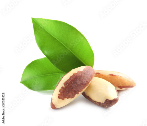 Brazil nuts with green leaves on white background