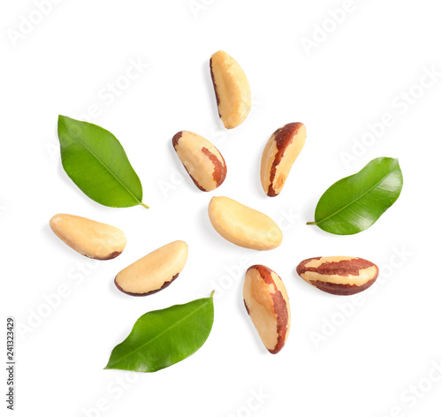 Composition with Brazil nuts and leaves on white background, top view