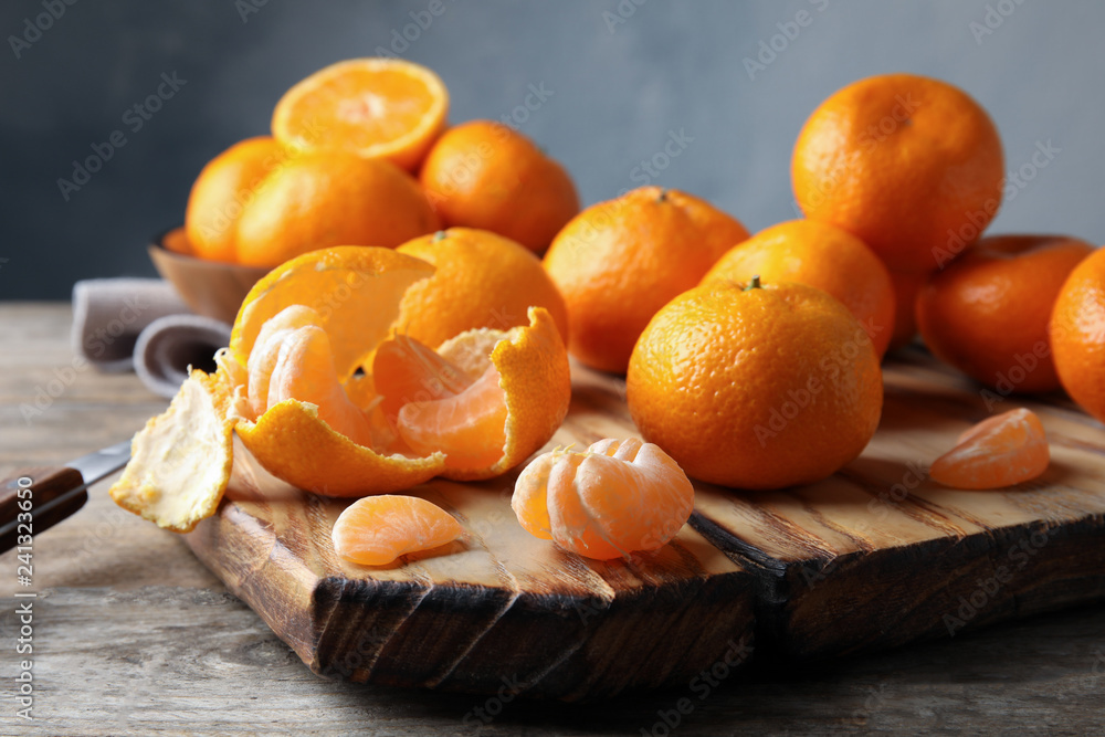 Board with ripe tangerines on wooden table Board with ripe tangerines on wooden table
