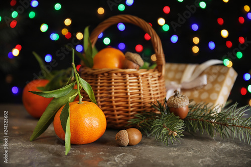 Composition with ripe tangerines and blurred Christmas lights on background